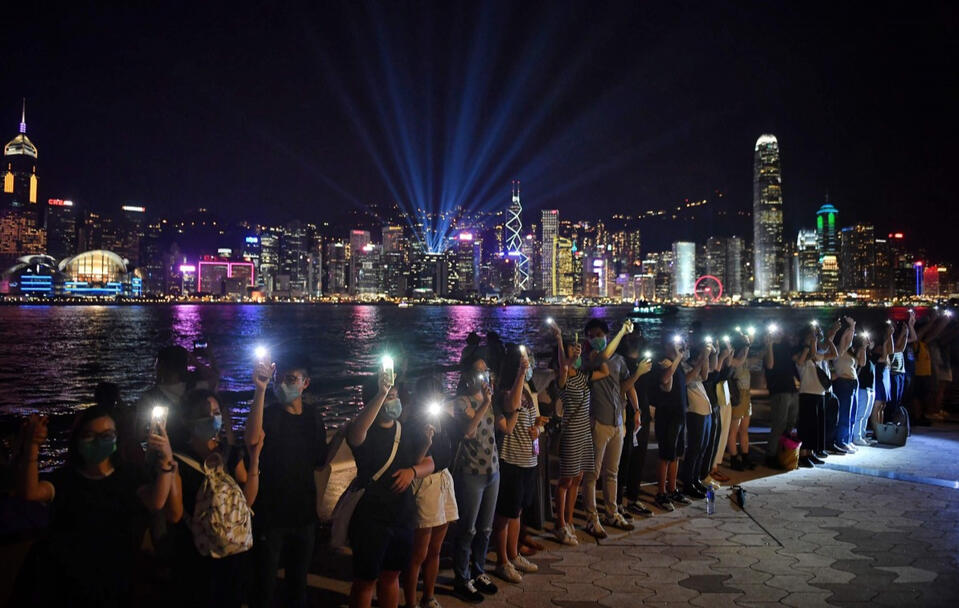 g hands against a victoria harbour night