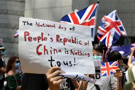rally attendees hold up british flags and signs